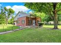 A charming brick home with a covered porch, beautiful landscaping and mature trees at 2601 Davis Rd, Indianapolis, IN 46239