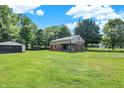Spacious green lawn featuring a charming brick home and a detached garage at 2601 Davis Rd, Indianapolis, IN 46239