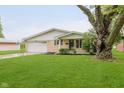 A well-kept single-story home featuring a lush green lawn and mature trees at 2925 E 8Th St, Anderson, IN 46012