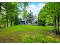 Beautiful lake house with expansive lawn, towering windows, and a spacious deck for outdoor enjoyment at 3695 Windsor Pl, Martinsville, IN 46151