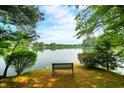 Scenic view of the serene lake, framed by lush trees, with a bench inviting peaceful reflection at 3695 Windsor Pl, Martinsville, IN 46151