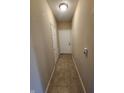 Inviting hallway with neutral walls and tiled floor leading to a bright white door at 5011 Amber Creek Pl # 205, Indianapolis, IN 46237