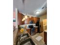 Well-equipped kitchen with stainless steel appliances, warm cabinetry and stainless steel sink at 5011 Amber Creek Pl # 205, Indianapolis, IN 46237