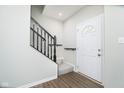 Welcoming entryway with staircase featuring a black railing and newel post and attractive wood grain floors at 5335 Rum Cherry Way, Indianapolis, IN 46237