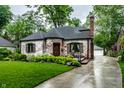 Charming brick home with lush landscaping, updated windows, and a brick chimney at 5677 Carrollton Ave, Indianapolis, IN 46220