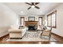 Bright living room featuring a fireplace, hardwood floors, and large windows at 5677 Carrollton Ave, Indianapolis, IN 46220