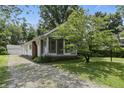 A delightful home with a screened porch, a brick chimney and an outdoor garage, all surrounded by lush trees at 6125 Winthrop Ave, Indianapolis, IN 46220