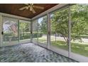 A sunroom with many windows overlooking a yard filled with trees that allow plenty of natural light at 6125 Winthrop Ave, Indianapolis, IN 46220