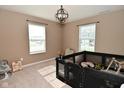 Bright room with two windows, neutral carpet and a playful arrangement of furniture at 680 Albermarle Dr, Pittsboro, IN 46167
