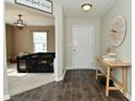 Charming entryway featuring hardwood floors, a decorative table, and a glimpse into the cozy living area at 680 Albermarle Dr, Pittsboro, IN 46167
