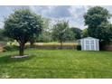 Lush backyard featuring mature trees, a wood fence, and a storage shed at 7175 Oakview Dr, Avon, IN 46123