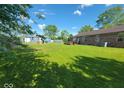 Spacious backyard featuring lush green grass, a fire pit, and a view of the house at 724 Iroquois St, Anderson, IN 46012