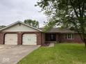Traditional brick home with an attached two-car garage and a neatly kept front lawn at 724 Iroquois St, Anderson, IN 46012