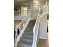 Bright foyer with a carpeted staircase, leading to the second floor with white banisters and modern neutral paint at 7532 Perilla Ct, Indianapolis, IN 46237