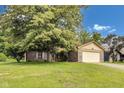 Charming brick home with an attached two-car garage and a well-manicured lawn at 7583 Rogers Dr, Indianapolis, IN 46214