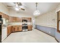 Cozy kitchen with wood cabinets, stainless steel appliances, and vintage wallpaper at 7583 Rogers Dr, Indianapolis, IN 46214