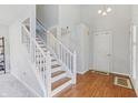 Bright foyer with hardwood floors and a staircase with white railings at 7766 Jamestown S S Dr, Fishers, IN 46038
