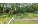 Spacious backyard enclosed by a chain-link fence with mature trees at 7879 Main St, Coatesville, IN 46121
