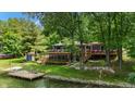 Charming lake house featuring decks, screened in porch, dock and stairs to the lake at 8426 N Chickadee Dr, Morgantown, IN 46160