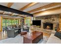 Cozy living room features a stone fireplace, wood beams, and waterfront views at 8426 N Chickadee Dr, Morgantown, IN 46160