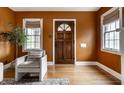 Warm entryway featuring hardwood floors, an inviting wooden door, and natural light from two windows at 948 N Layman Ave, Indianapolis, IN 46219