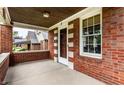Inviting brick porch, showcasing a classic design with a window and an exterior door at 948 N Layman Ave, Indianapolis, IN 46219