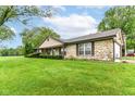 Sprawling ranch-style home with stone exterior, large front yard, and mature trees creates inviting curb appeal at 9608 Sycamore Rd, Carmel, IN 46032