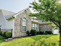 Brick home with lush green yard and dark window shutters at 1176 Everton Ct, Greenwood, IN 46143