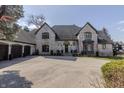 Elegant brick home featuring a circular driveway and manicured front yard landscaping at 11931 Promontory Ct, Indianapolis, IN 46236
