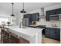 Contemporary kitchen featuring navy cabinets, a white quartz island, and stainless steel appliances at 1315 Colere Pl, Indianapolis, IN 46203