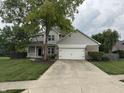 Charming two-story home with a well-manicured lawn, mature trees, and an attached two-car garage at 1378 Runningbrook Dr, Avon, IN 46123