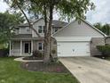 Beautifully landscaped front yard with a well-manicured lawn and an attached two-car garage at 1378 Runningbrook Dr, Avon, IN 46123