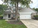 Two story home with attached garage and manicured front lawn and landscaping at 1378 Runningbrook Dr, Avon, IN 46123