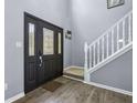 Bright foyer showcasing a decorative front door, staircase, and luxury vinyl plank flooring at 13938 Charleswood Ct, Fishers, IN 46038
