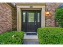 Close up of a front door with decorative glass and sidelights, framed by manicured shrubs at 13938 Charleswood Ct, Fishers, IN 46038