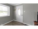 Entryway with a white door featuring an oval window, gray walls, and stylish laminate flooring at 141 S 9Th Ave, Beech Grove, IN 46107