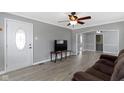 Bright living room with neutral walls, ceiling fan, laminate floors, and a view into adjoining rooms at 141 S 9Th Ave, Beech Grove, IN 46107