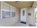 Inviting covered porch featuring a white front door with oval glass insert, complemented by neutral siding and a window at 141 S 9Th Ave, Beech Grove, IN 46107
