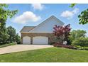 Attached two-car garage, complemented by a well-maintained lawn and beautiful landscaping at 16802 Oak Manor Dr, Westfield, IN 46074