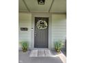 Close-up of front door, complete with decor, potted plants, and secure entry at 1709 Fletcher Ave, Indianapolis, IN 46203