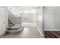 Inviting entryway showcasing tile flooring transitioning to carpet, with stairs leading to the upper level at 1829 Archbury Dr, Avon, IN 46123