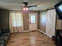 Inviting living room featuring wood flooring, barn doors and large window for ample lighting at 2041 Mckinley Ave, Columbus, IN 47201