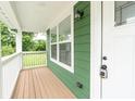 This covered front porch features wood decking and is perfect for enjoying the outdoors at 2427 N Rural St, Indianapolis, IN 46218