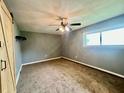 Cozy bedroom featuring neutral carpet, a ceiling fan, window, and a modern sliding barn door at 2833 Desoto Way, Columbus, IN 47203