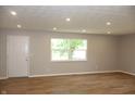 Bright living room with wood floors, neutral walls, and natural light from the large window at 3026 Stuart St, Indianapolis, IN 46218
