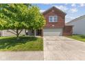 Traditional two-story home with brick and siding, a well-kept lawn and attached two-car garage at 3349 Capsella Ln, Indianapolis, IN 46203