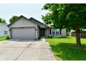 Charming single Gathering home with a well maintained lawn and concrete driveway leading to a two car garage at 3429 Pavetto Ln, Indianapolis, IN 46203