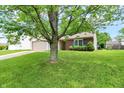 Exterior view of a single-story home with a well-manicured lawn and mature tree in the front yard at 4007 Knollwood Ave, Franklin, IN 46131