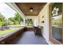 Inviting covered porch with brick accents, comfortable seating, and a view of the neighborhood at 4137 Rookwood Ave, Indianapolis, IN 46208