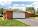 This inviting brick home includes an attached two car garage and well manicured lawn at 418 Dunbar Dr, Indianapolis, IN 46229